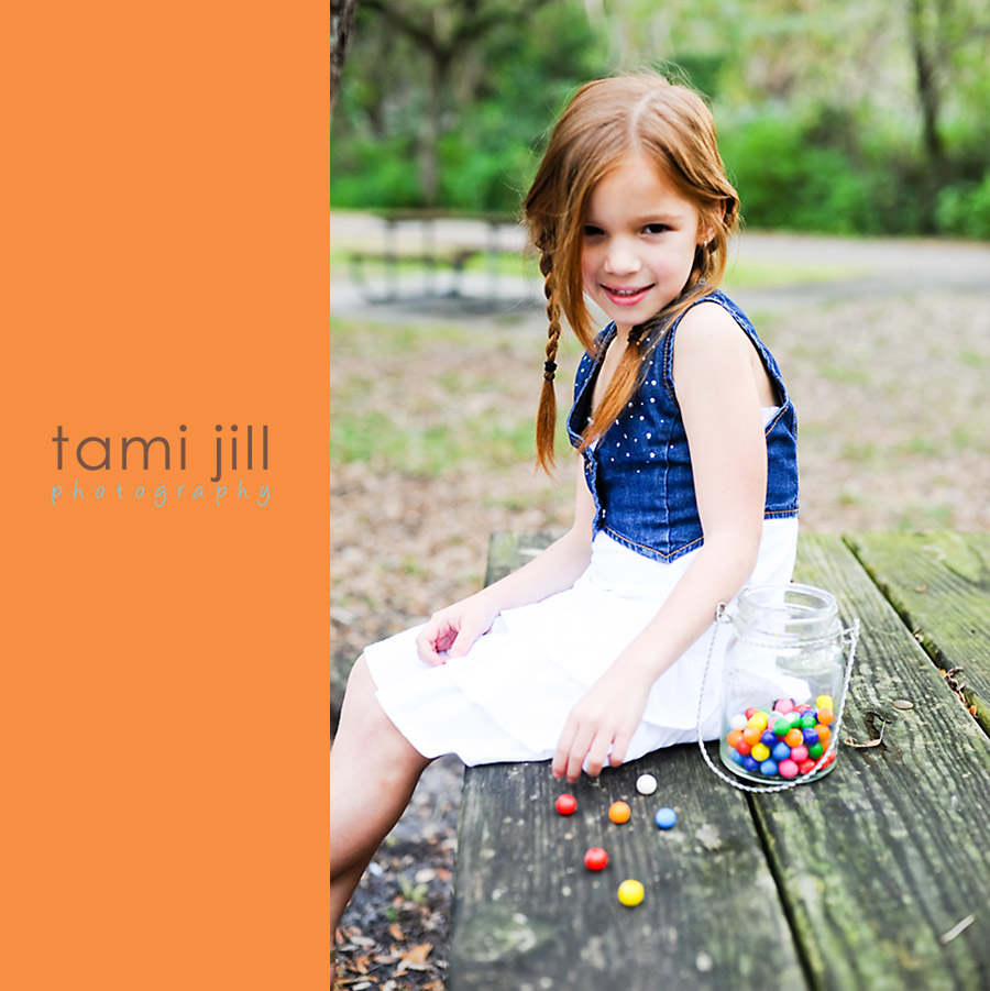 Little girl plays with vintage jar of bubblegum on park bench.