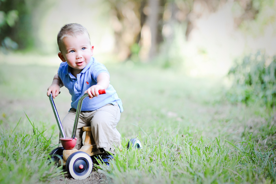 Toddler on old fashion red bike.